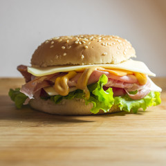 Panino con mortadella,formaggio, pomodoro e insalata su tagliere di legno