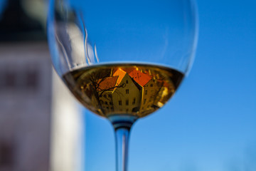 Glass of white wine with old Tallinn reflection