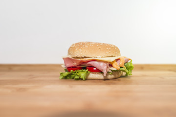 Panino con mortadella,formaggio, pomodoro e insalata su tagliere di legno