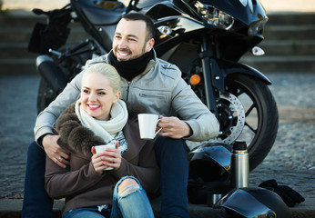 Couple posing near motor bike