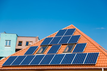 Fototapeta premium Solar panels on the red roof of a building