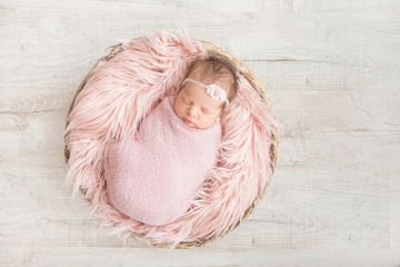 sleeping newborn baby in a basket - obrazy, fototapety, plakaty
