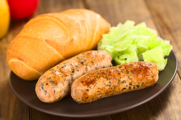 Bratwurst mit Brötchen auf Teller serviert (Selektiver Fokus, Fokus auf die rechte Seite der...