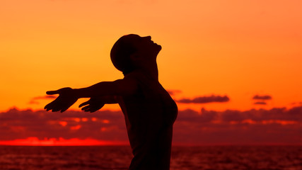 Woman's silhouette on sunset background