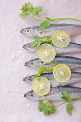 sardines with lemon wedges, sea salt and parsley on tracing paper