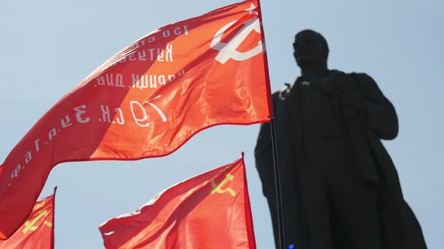 Monument to Vladimir Lenin end soviet flag flying.
