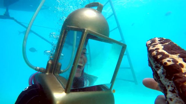 Girl in the helmet looks at sea creatures at the Bermuda Helmet Diving tour. 