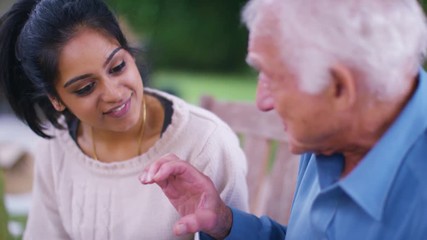Caring home support worker with elderly man in the garden - Powered by Adobe