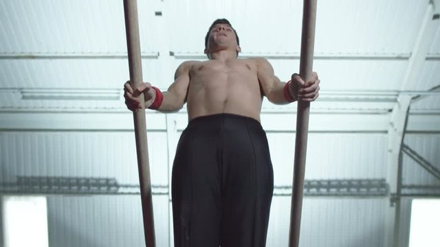  Professional male gymnast training on parallel bars at the gym