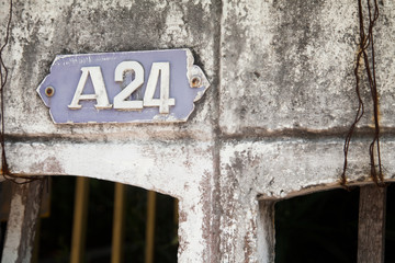 Old house number plate, plaque A 24 on a very shabby old wall