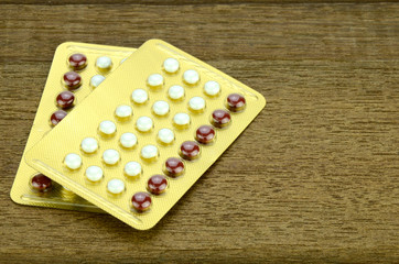 Oral Contraceptive on wood background.