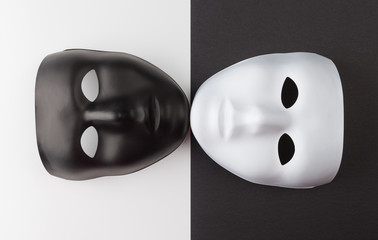 Black and white masks touching chins on contrasting backgrounds, Personality change theatrical...