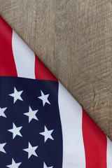 Fragment of American flag folded on wooden walnut table. Vertical image with copy space.