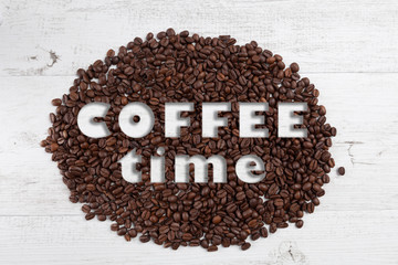 Coffee time text on scattered roasted coffee beans on white rustic wooden background - Powered by Adobe