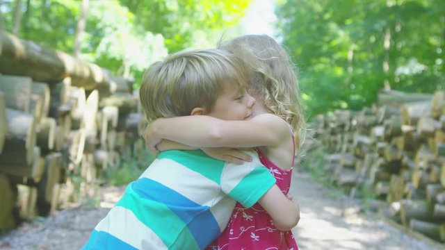  Happy little boy & girl in the woods share a hug