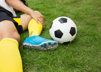 Foto op Plexiglas Close-up Of Injured Football Player On Field. © sirikornt