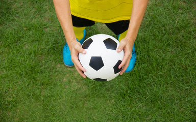 Soccer player holding a football.