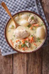 Creamy soup with chicken and vegetables close up. Vertical top view

