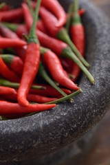 Heap of fresh red chili peppers in stone mortar