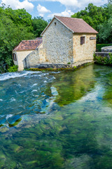 Fototapeta na wymiar Krka national park, Croatia - May 05, 2016: historic buiding by rapids