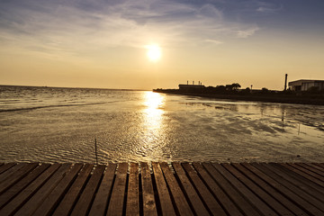 Fototapeta na wymiar wooden bridge with beautiful sunset background above the sea, warm tone