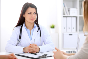 Brunette female doctor talking to patient in the hospital