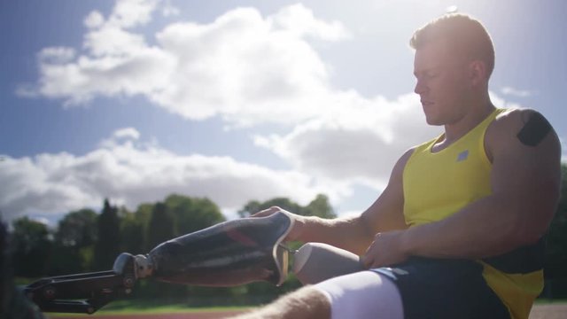  Disabled Athlete With Prosthetic Leg At The Running Track Putting On His Limb Before Competing. 