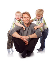 Caucasian happy father with two children sitting on the floor.