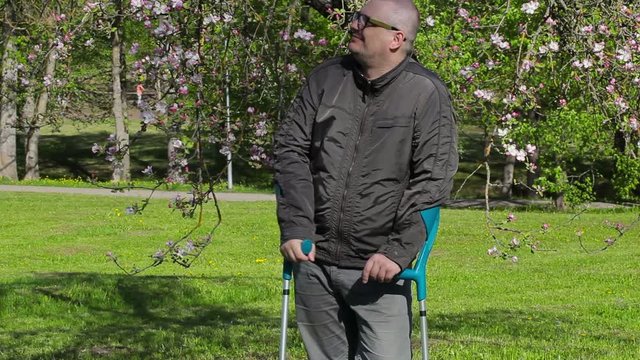 Disabled man with crutches enjoy nature