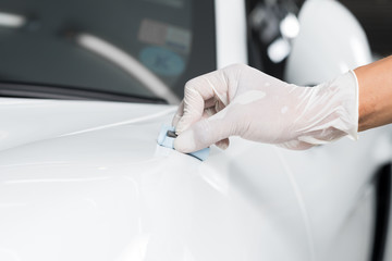 Obraz na płótnie Canvas Car detailing series : Closeup of hand coating white car paint