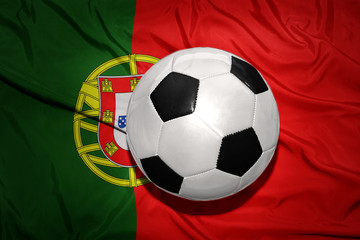 Naklejka premium black and white football ball on the national flag of portugal