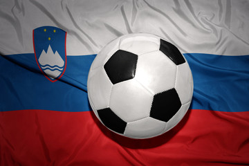 Naklejka premium black and white football ball on the national flag of slovenia