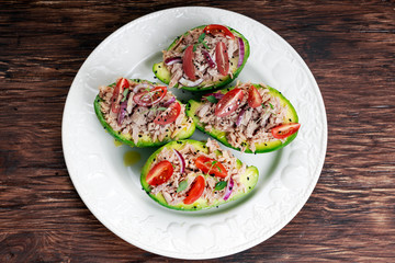 Avocado boats stuffed with tuna, red onion and cherry tomatoes.