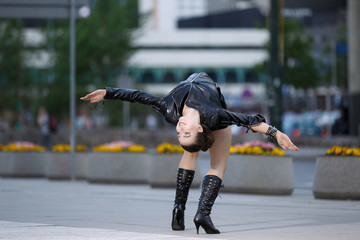 Beautiful woman performing acrobatics in the city