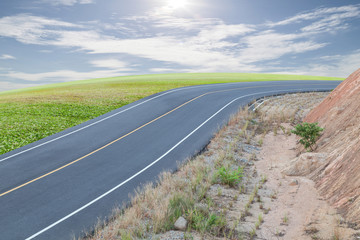 Asphalt Road with green grass ,blue sky  background.