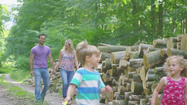  Happy family spending time outdoors & walking pet puppy along forest path