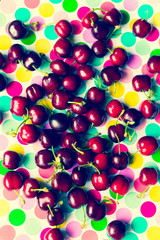 group of cherries on colorful polka dot trend background, minima theme