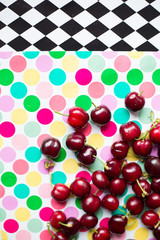 group of cherries on colorful polka dot trend background, minima theme