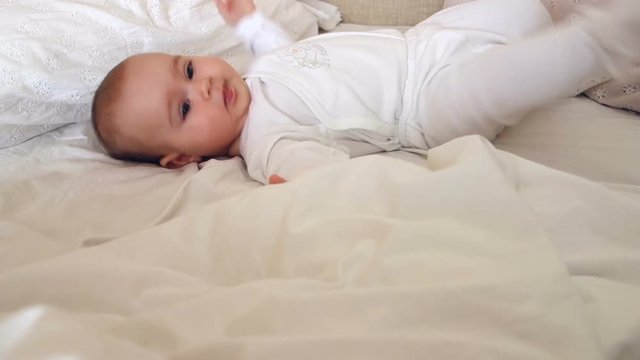 Baby girl rolling on the bed having fun 