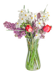 White daffodils flowers, lilac flowers and tulips, transparent vase