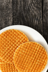 Waffles stroopwafel on a plate on dark wood