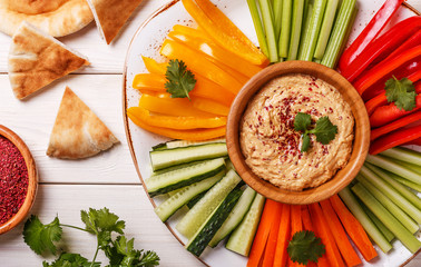 Homemade hummus with assorted fresh vegetables and pita bread. - obrazy, fototapety, plakaty