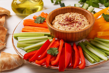 Homemade hummus with assorted fresh vegetables and pita bread.