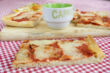 slice of margherita pizza with cup of cappuccino