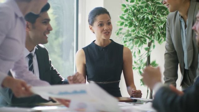  Confident business group in negotiation meeting shake hands on a deal.