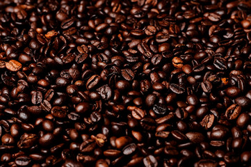 Flying coffee beans isolated on black background. Roasted coffee grains explosion.