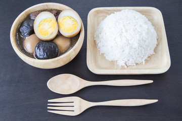 Five spice pork and egg stew with wooden kitchenware on black ba