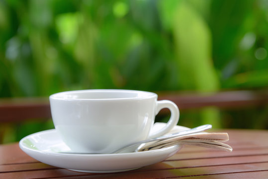 White coffee cup with blurred garden background