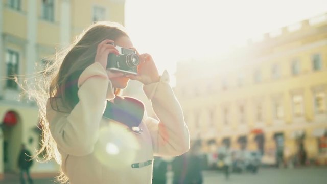 young female taking pictures of a city with an old camera slow motion