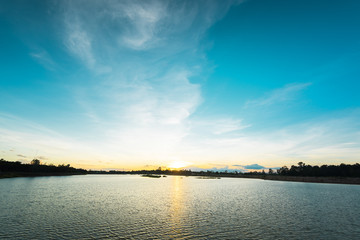 Fototapeta na wymiar Sunset landscape over the lake with blue sky